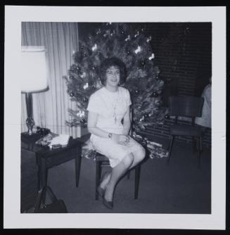[Gisele sitting in front of a Christmas tree, location unknown]
