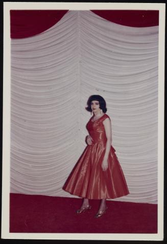 [Karen in a coral dress posing on the stage at the Chevalier d’Éon, Halloween party, Hunter, NY]
