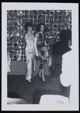 [Two brunettes in satin dresses, location unknown]

