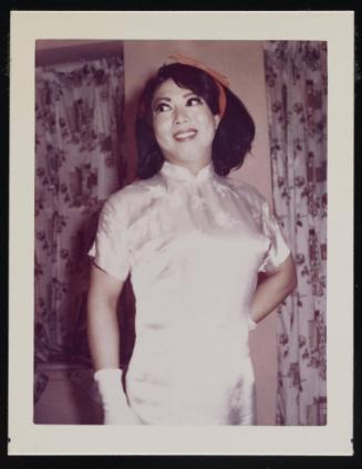 [Lili with a red ribbon, posing in front of floral curtains, location unknown]
