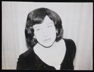 [Gail wearing Gloria's wig, location unknown]
