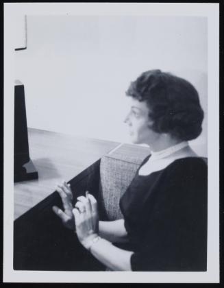 [Anita wearing a pearl necklace, location unknown]
