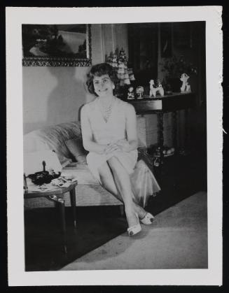 [Edith sitting with ankles crossed in Susanna and Marie’s New York City apartment]
