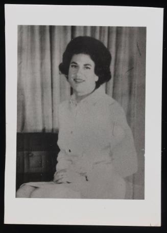 [Portrait of a brunette in white, location unknown]
